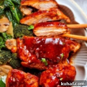 Thick gochujang sauce coating pan-seared chicken pieces with mushrooms in a bowl, ready to be served over rice.