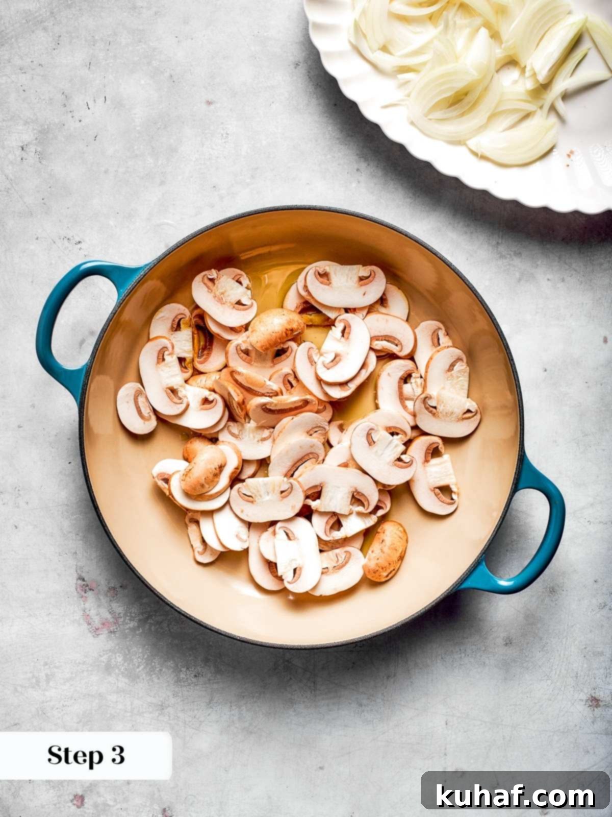 Sliced baby bella mushrooms cooking in hot oil, taking on a golden-brown color and softening in a large skillet, ready for the next step.