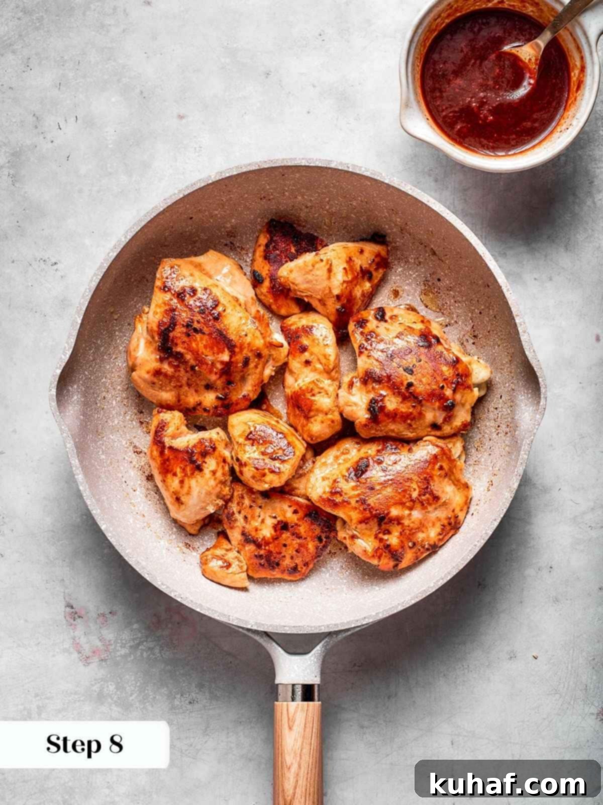 Chicken pieces browning in a hot skillet, showing a crispy golden-brown sear before the gochujang sauce is added, indicating proper searing technique.
