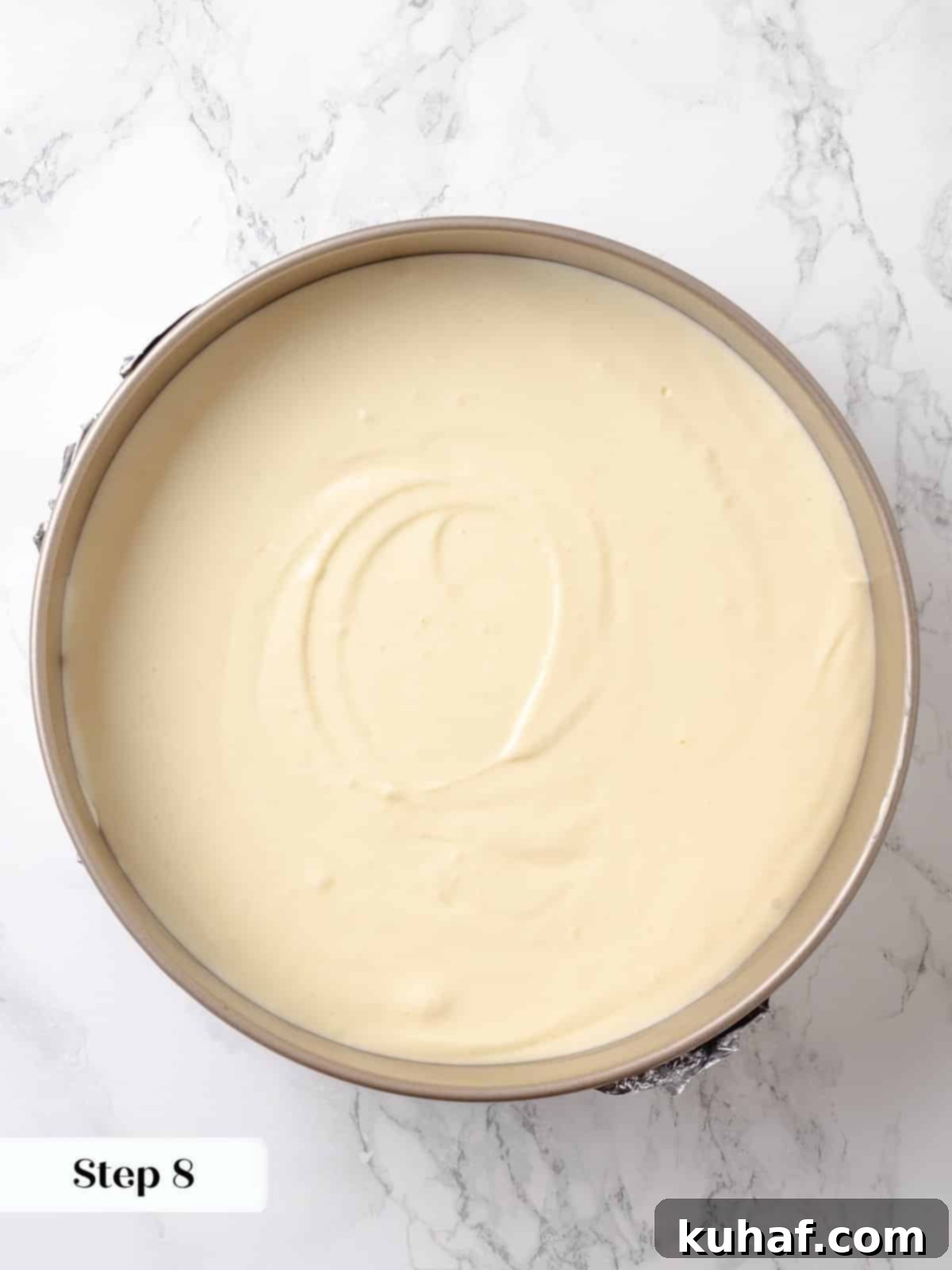 Pan filled with creamy cheesecake batter ready to bake in a hot water bath.