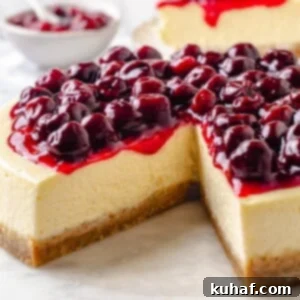 Homemade cherry topping drips down the side of creamy cheesecake with a golden brown crust.