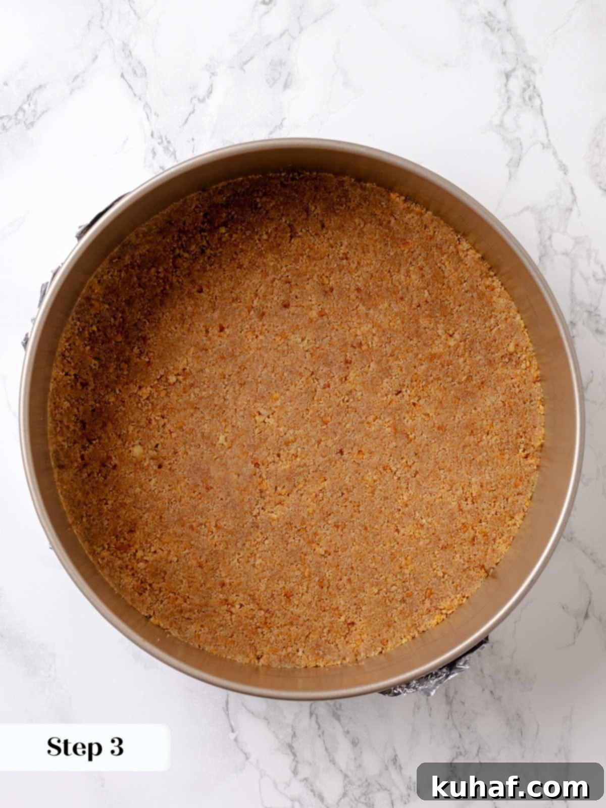 Graham crust fully baked and golden brown, cooling before adding the cheesecake filling.