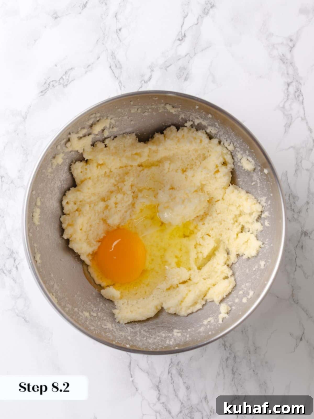 Egg is cracked and stirred into the base mixture for the cake.