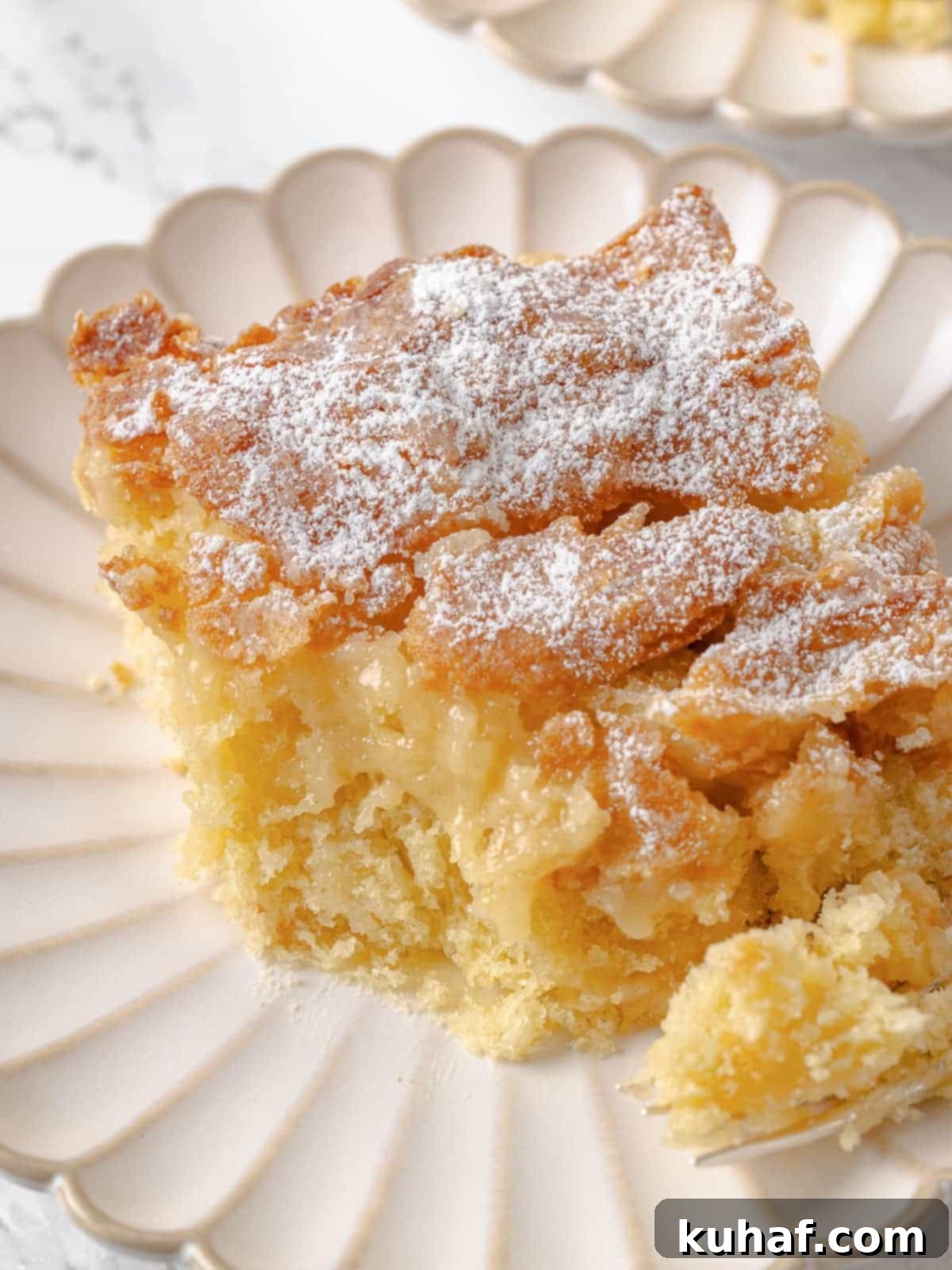 A single slice of cake with a bite taken, showing soft texture and moist center.