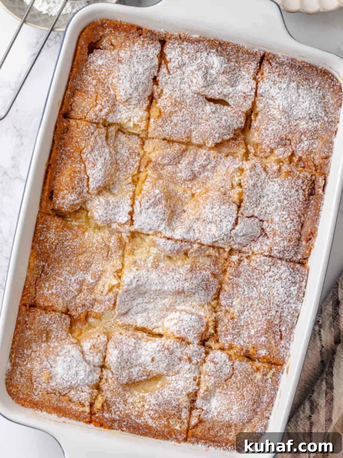 Gooey butter cake sliced into squares with visible gooey topping and soft crumb.