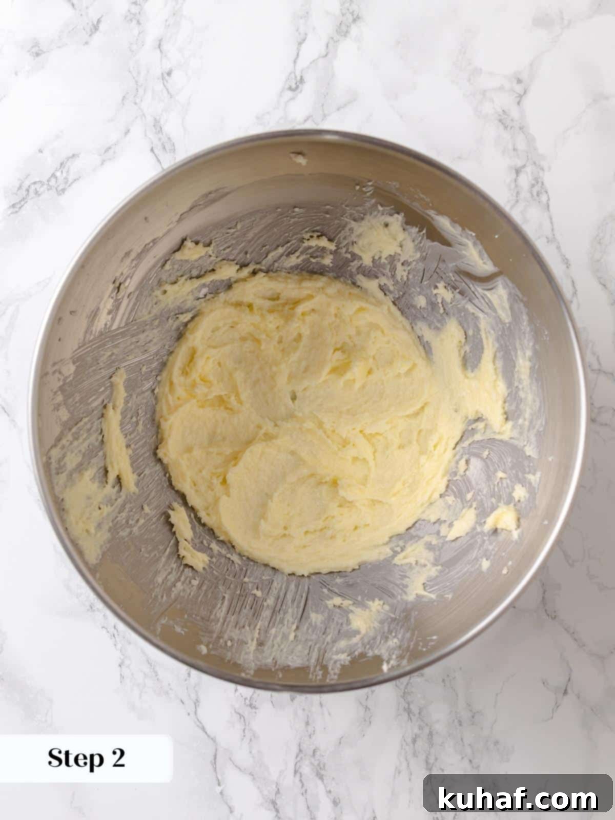 Butter and sugar mixture is creamed until lightened, forming the first step of the cake.