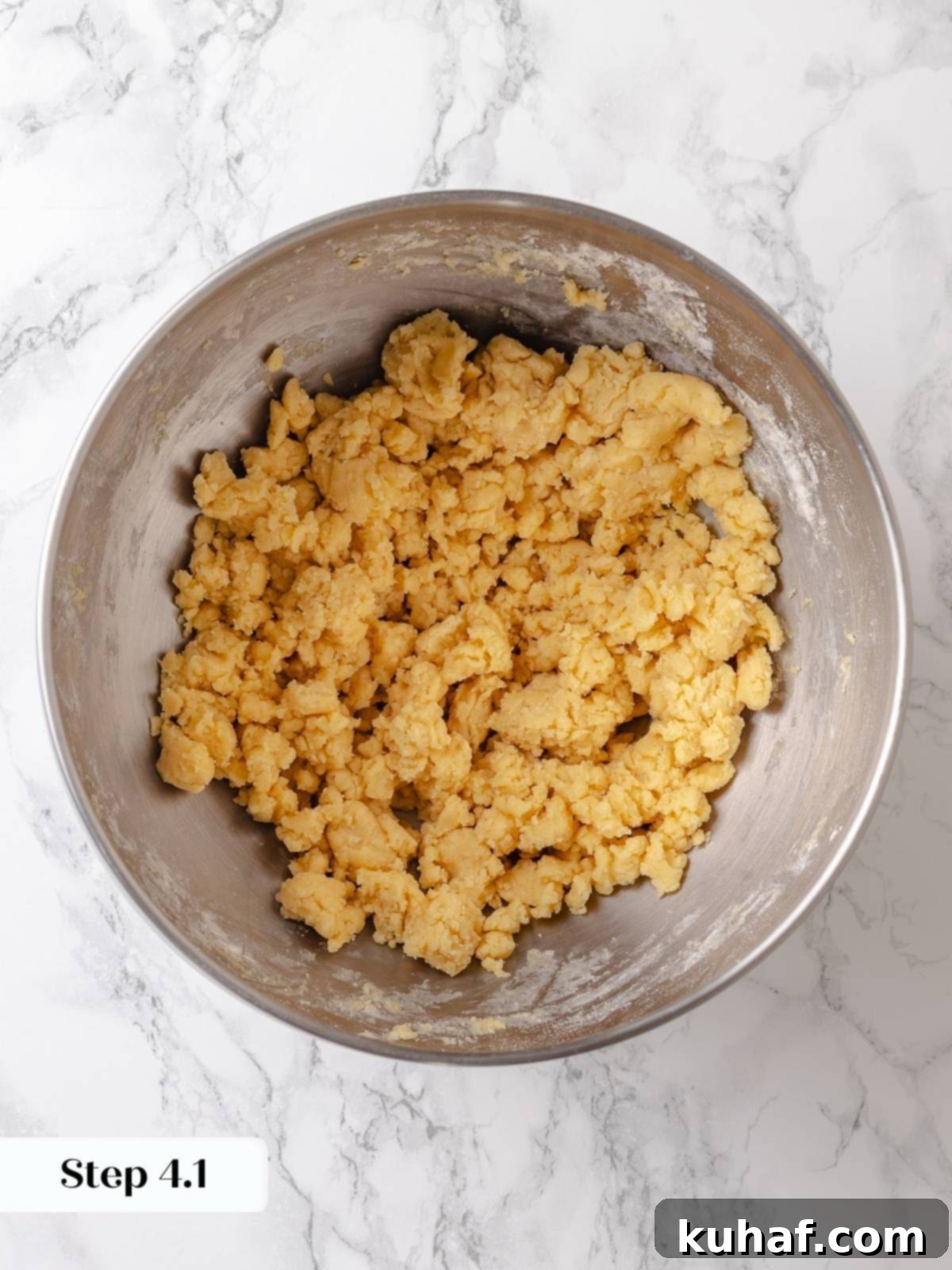 Mixing flour into the creamed ingredients during the early stage of cake batter preparation.