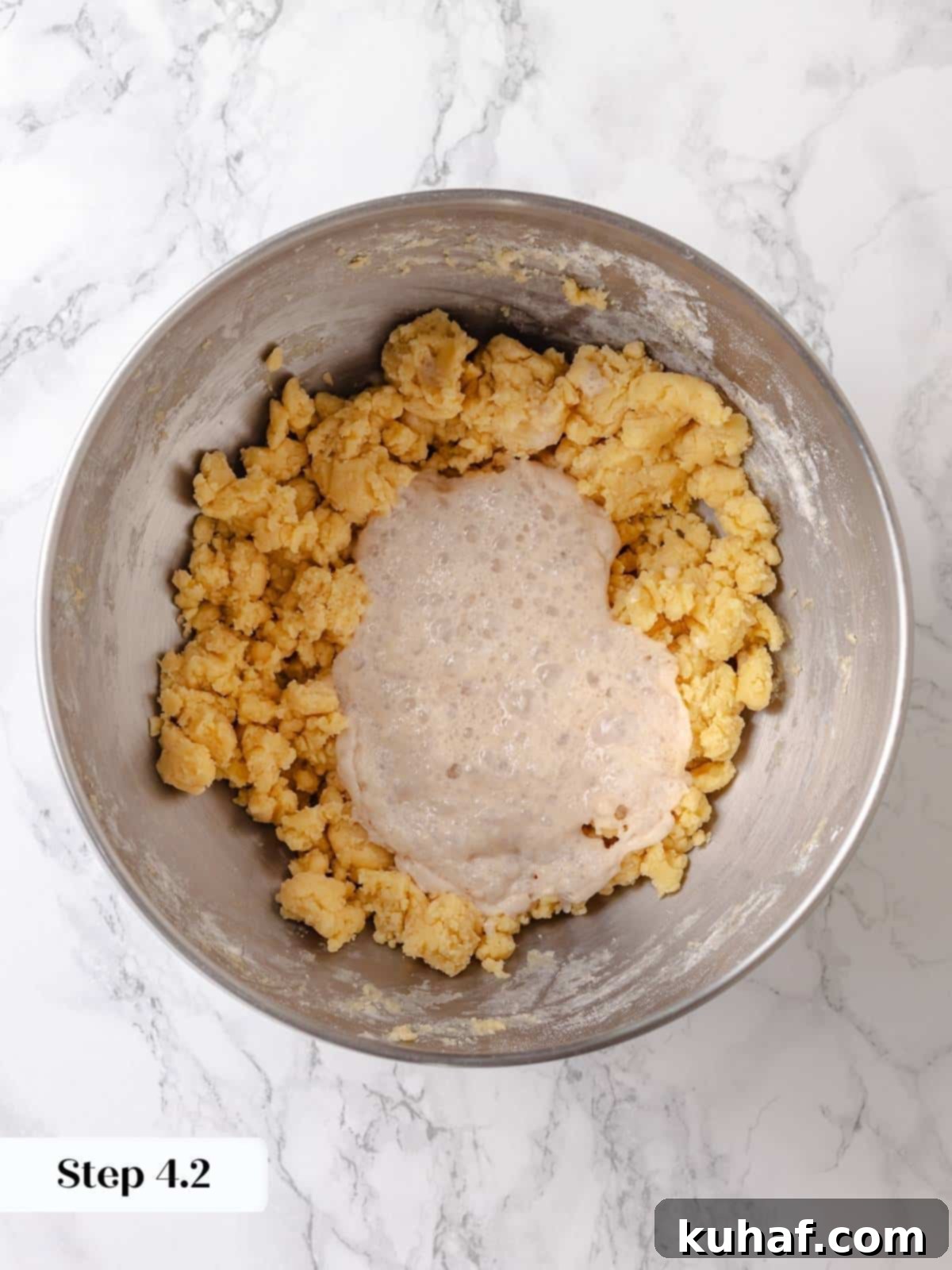 Activated yeast mixture is added to the butter mixture to begin building the dough.
