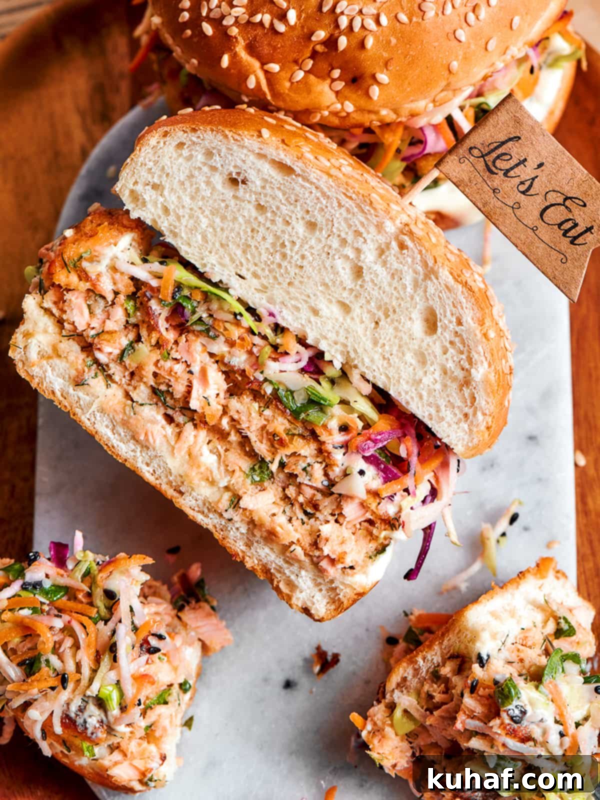 Salmon burger sliced in half to display flaked texture and visible herbs.