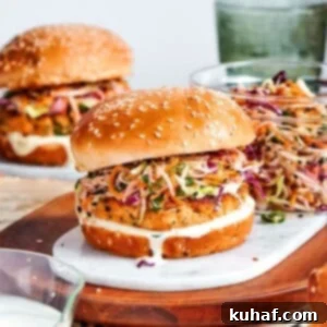 seasoned salmon patty showing fresh herbs and lemon zest inside assembled burger.