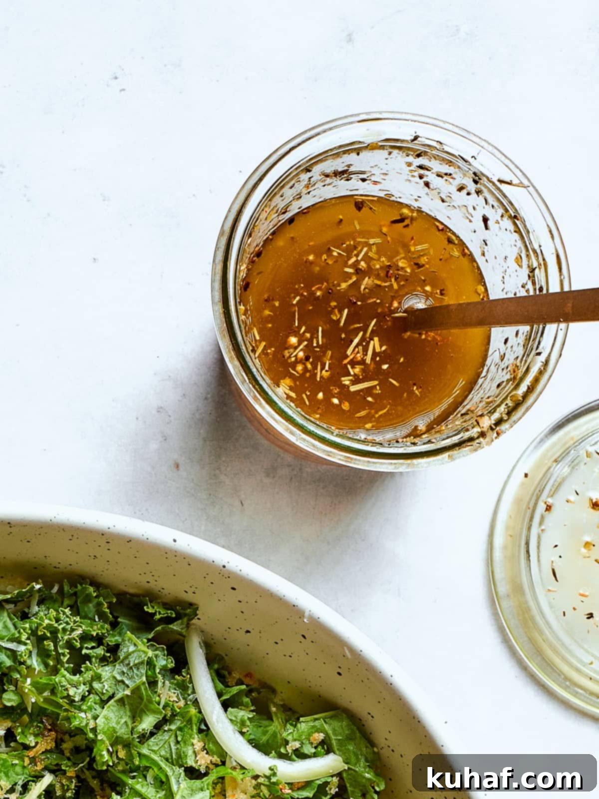 homemade Italian salad dressing with flecks of oregano and cheese in a glass jar, ready to serve.