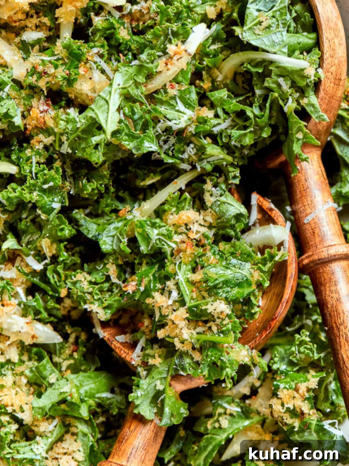A spoonful of Tuscan kale salad showing tender ribbons of kale, onions, and crispy breadcrumbs.