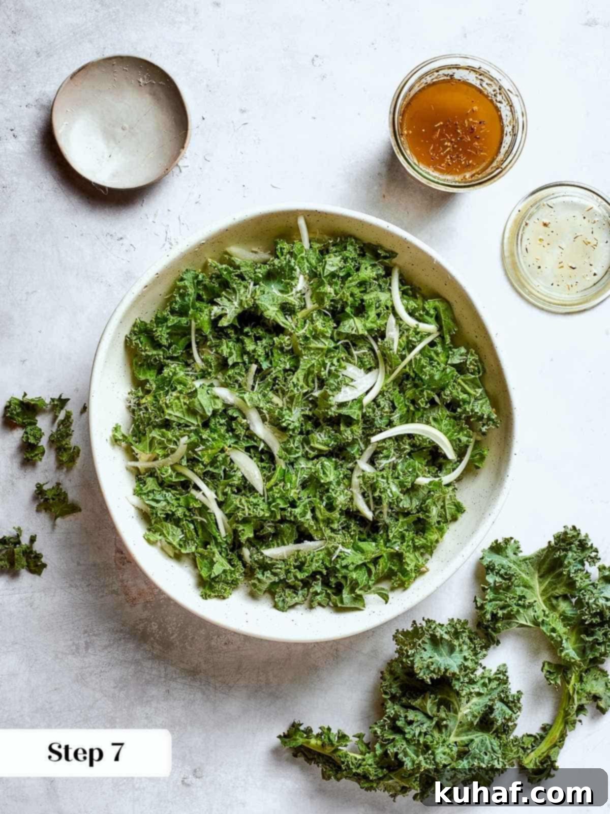 Chopped kale and thin onion slices mixed for Tuscan kale salad.
