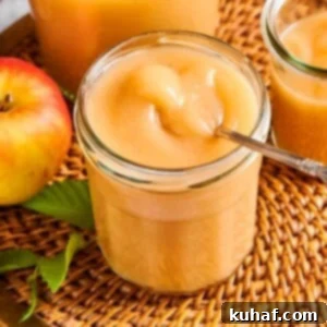 Easy 2 Ingredient Applesauce 9 Homemade applesauce in a jar resting on a wicker placemat, surrounded by natural autumn light.