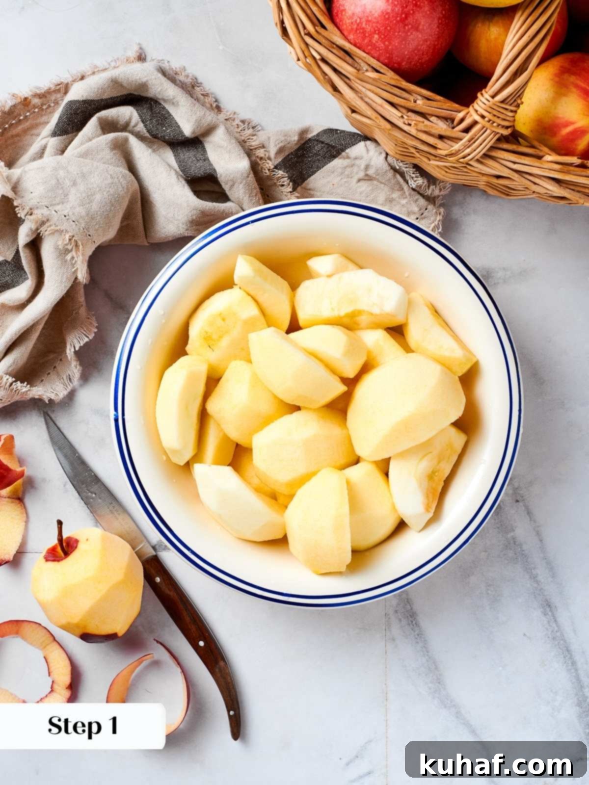 Easy 2 Ingredient Applesauce 5 Fresh apples being peeled and quartered on a countertop, preparing ingredients for homemade applesauce.