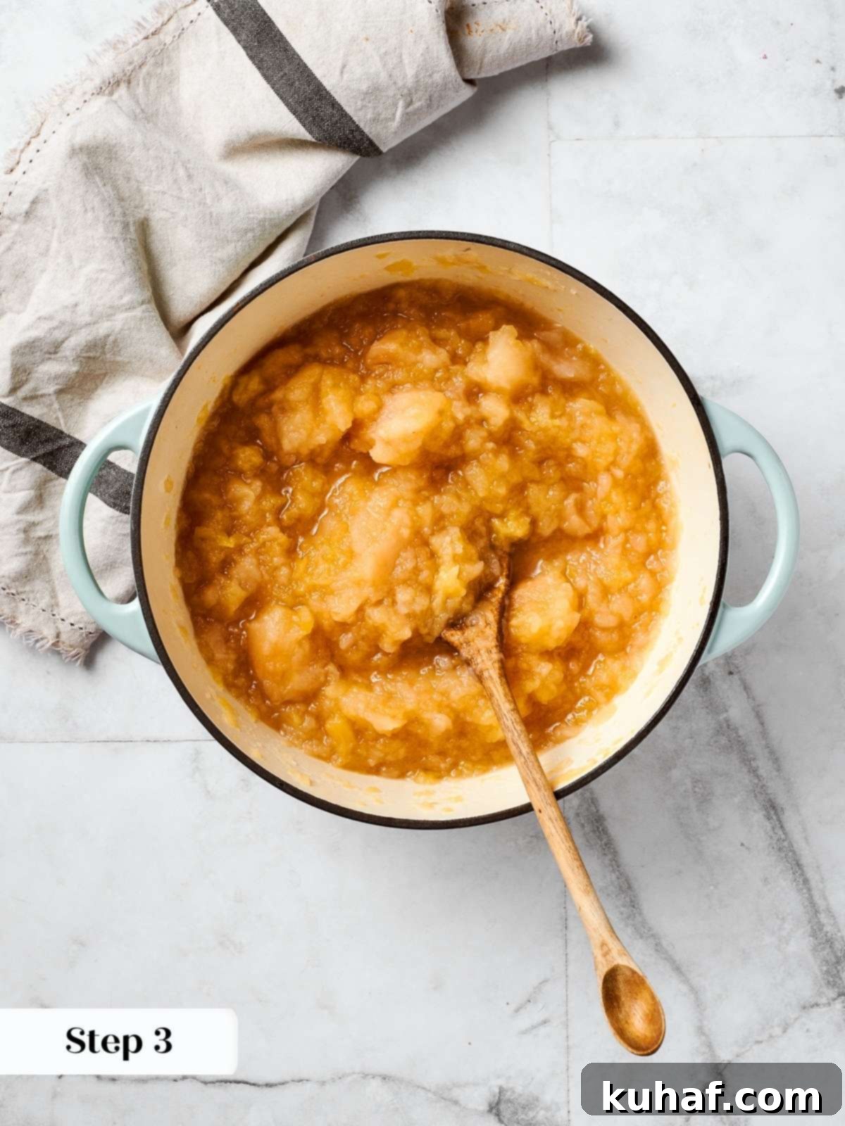 Easy 2 Ingredient Applesauce 6 Cooking apples with water in a large pot on the stovetop, demonstrating the initial stage of homemade applesauce preparation.