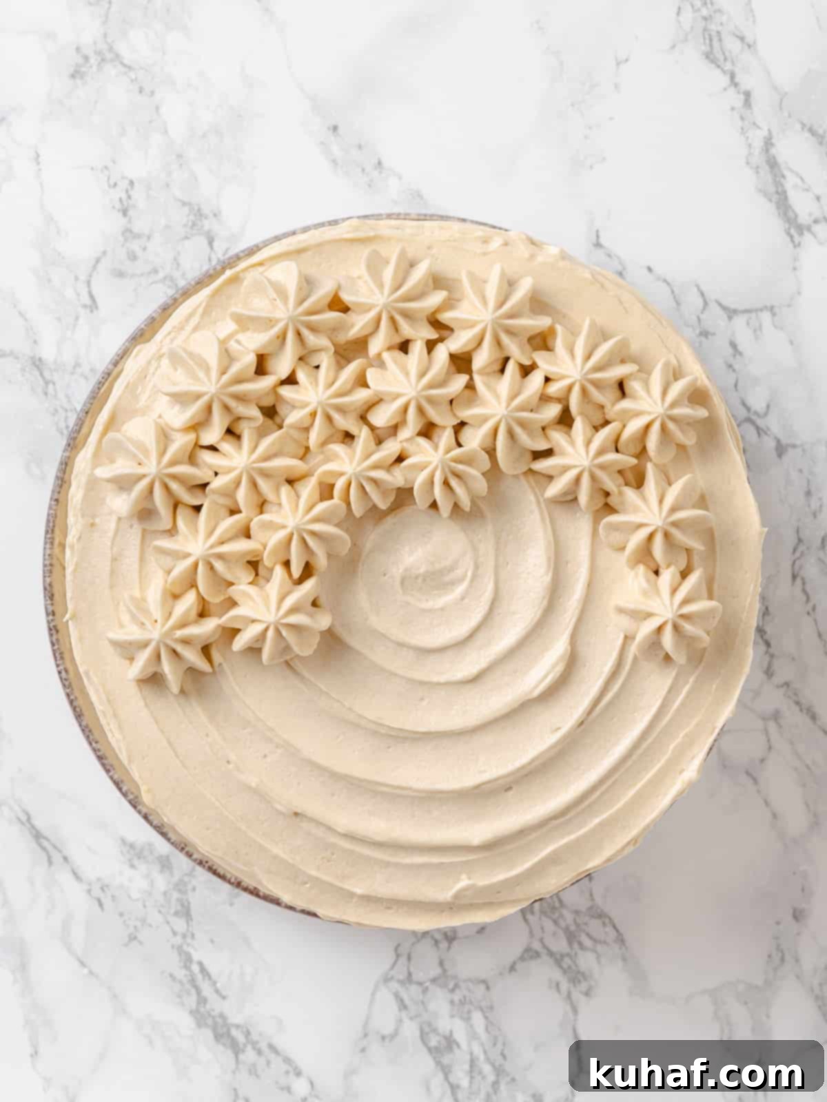 Golden Maple Frosting 11 Thick, creamy maple frosting swirled artistically across the surface of a cake, showing its luxurious texture and perfect pipeability.