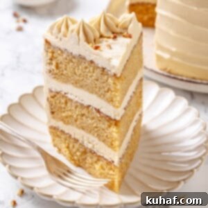 Pure Maple Indulgence 20 A delectable slice of maple cake on a pristine white plate, showcasing its beautifully defined layers and fluffy frosting.