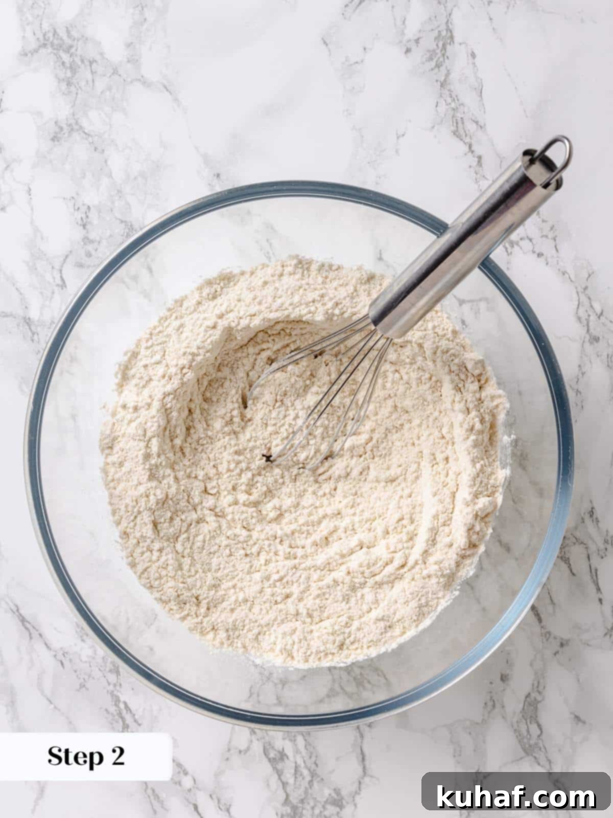 Pure Maple Indulgence 5 Bowl of all-purpose flour, salt, baking powder, and baking soda being whisked together to prepare dry ingredients for the maple cake.