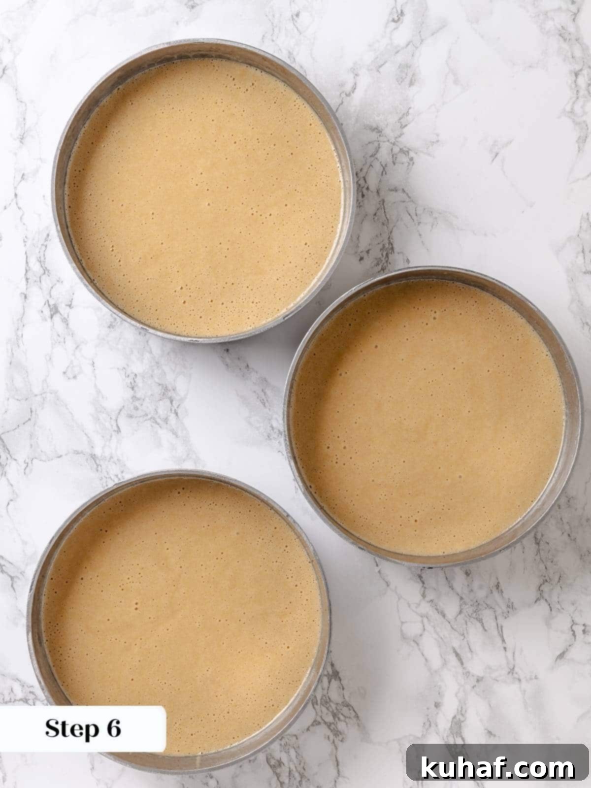 Pure Maple Indulgence 10 Smooth maple cake batter evenly divided and poured into prepared round cake pans, ready for baking.