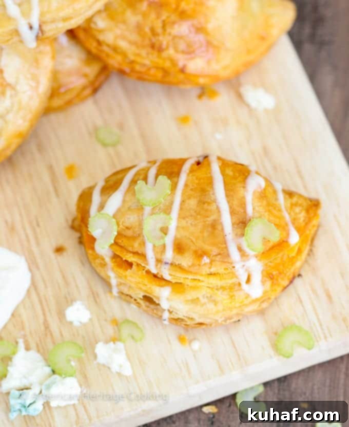 Close-up of a perfectly crimped Buffalo Chicken Blue Cheese Hand Pie, showcasing its golden, flaky crust.