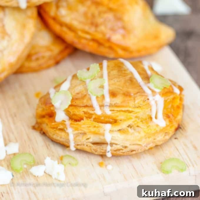 A large platter of Buffalo Chicken Blue Cheese Hand Pies, served with fresh celery sticks and a bowl of blue cheese dressing.
