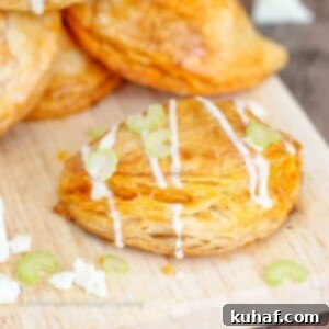 A close-up shot of a single Buffalo Chicken Blue Cheese Hand Pie, showcasing its golden crust and delicious filling.