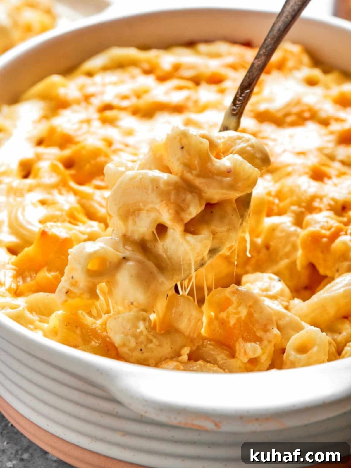 A deep casserole dish filled with creamy, cheesy baked mac and cheese, fresh from the oven, with a golden-brown top.