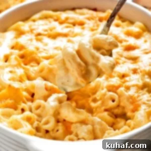 A large spoon lifting a creamy, cheesy scoop of baked mac and cheese.