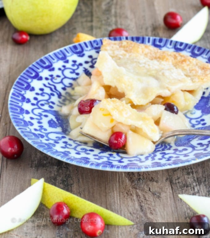 Close-up of the delightful Cranberry Orange Pear Pie, highlighting the juicy pears and bright red cranberries bursting through the filling.