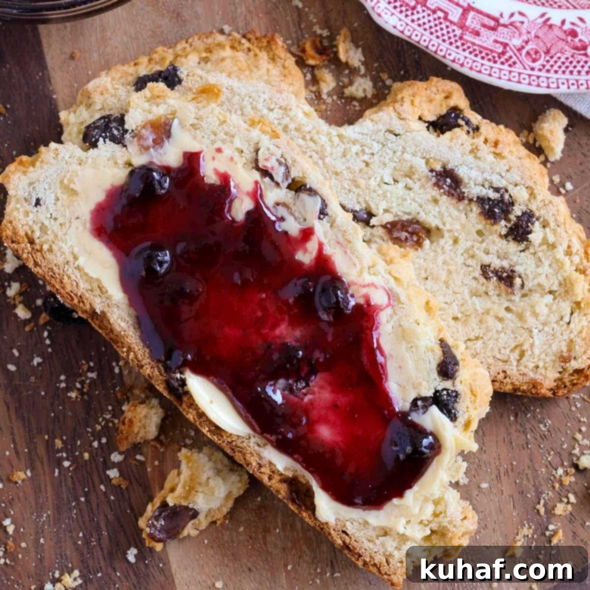 Classic Irish Soda Bread with Sweet Raisins 4 Two pieces of traditional Irish soda bread, one with butter and one with jam, ready to be enjoyed.