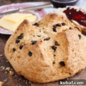 Classic Irish Soda Bread with Sweet Raisins 5 A beautiful round loaf of traditional Irish soda bread with raisins, with a block of butter in the background.