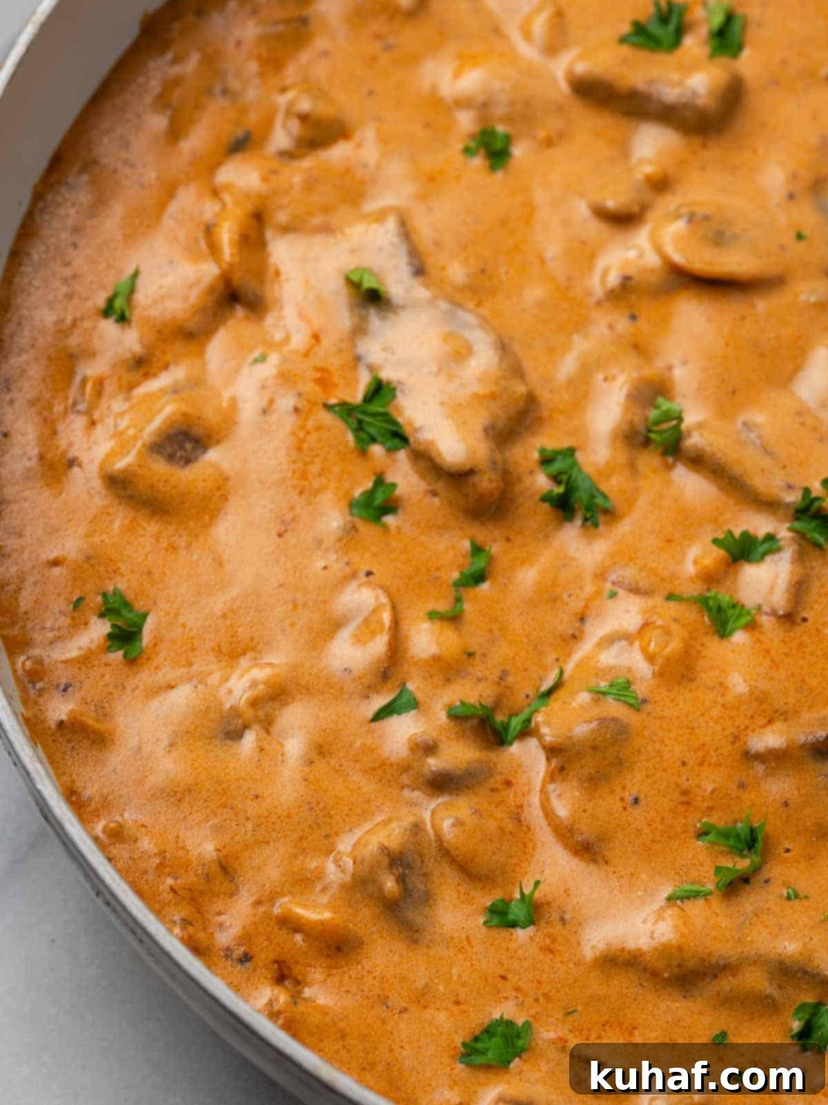 Finished cooked beef stroganoff with chopped parsley on top, ready to serve.
