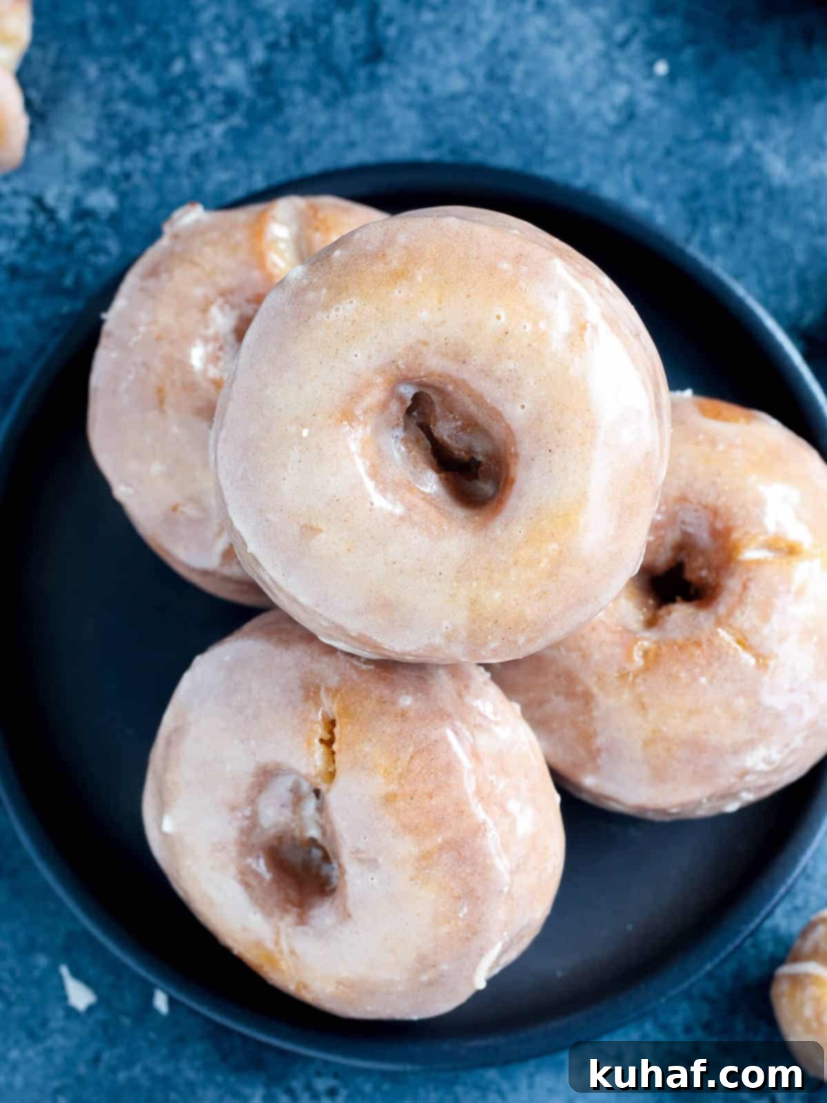pumpkin cake donuts stacked on black plate. 