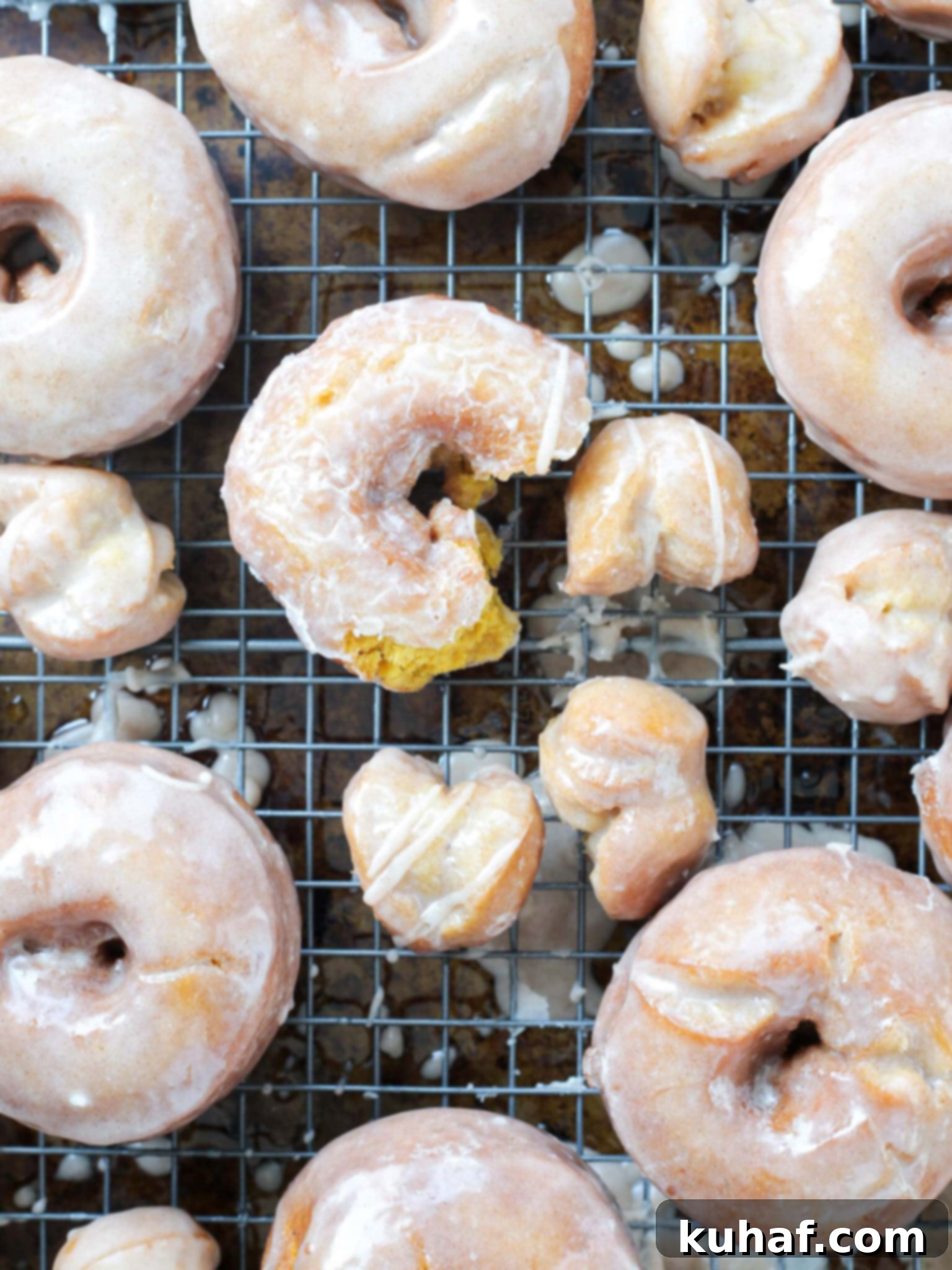 fried pumpkin donuts glazed on wire rack.