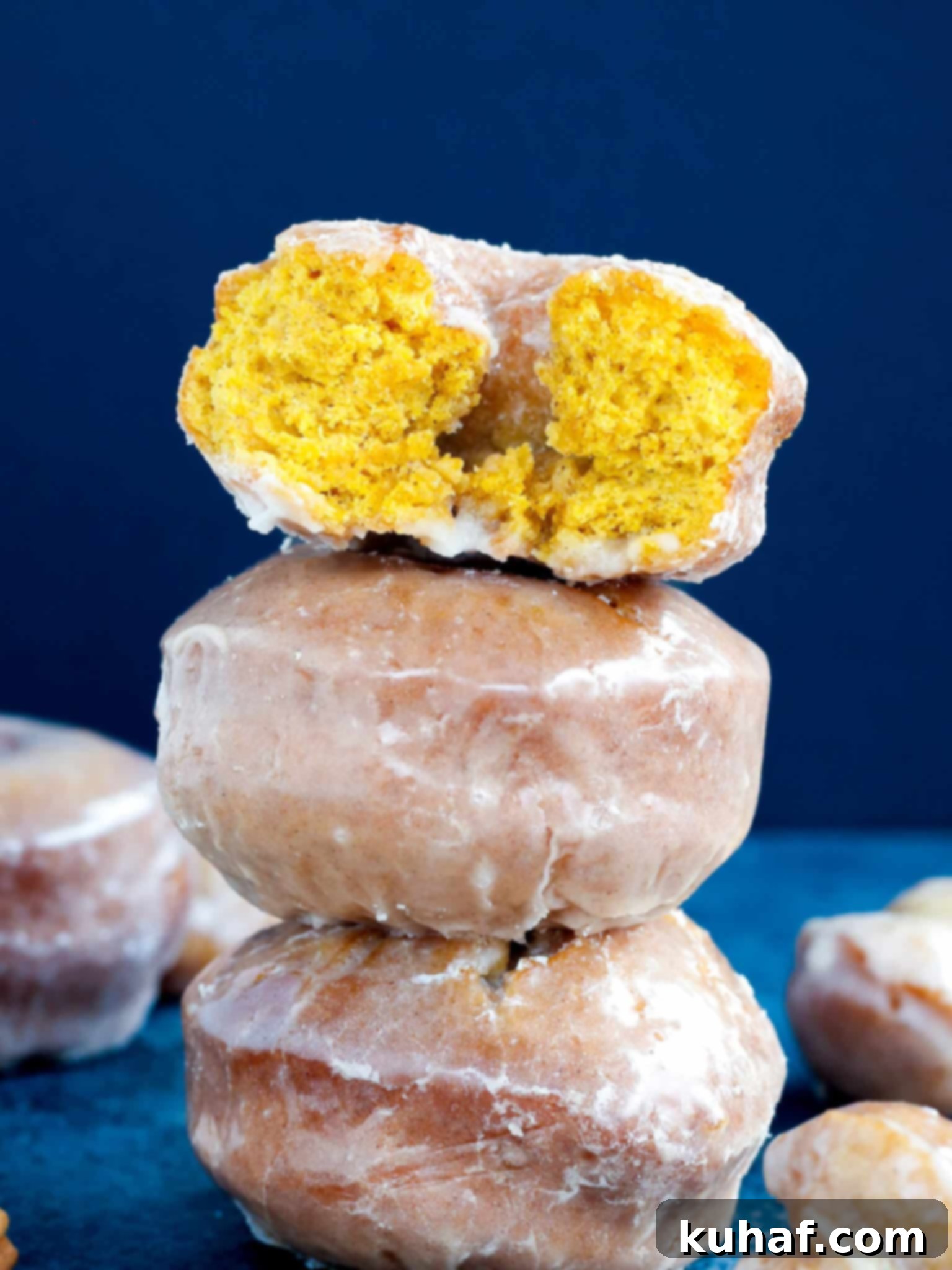 three pumpkin donuts stacked.