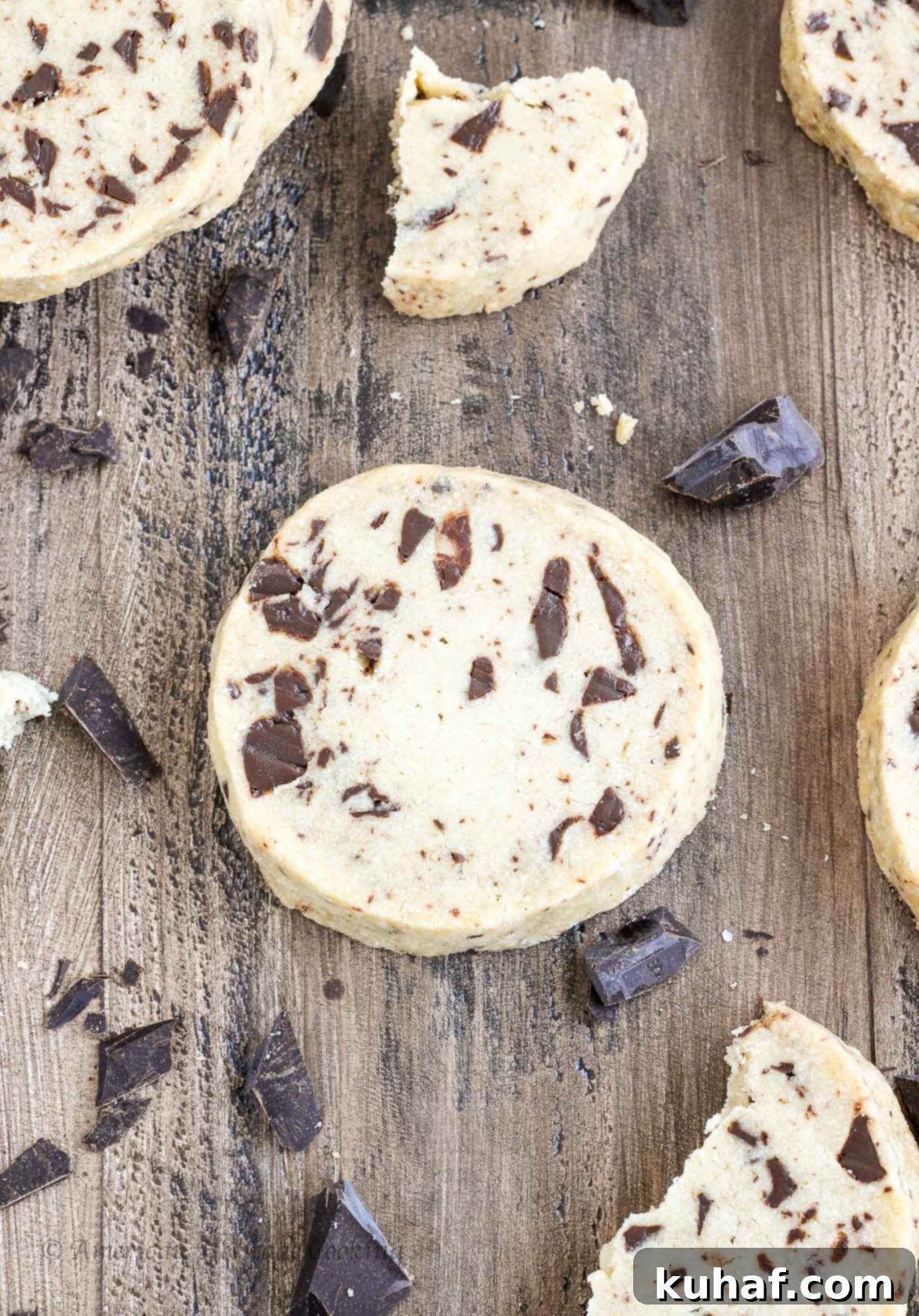 Chocolate chip shortbread cookies artfully arranged on a rustic wooden background, highlighting their golden edges and melty chocolate chips.