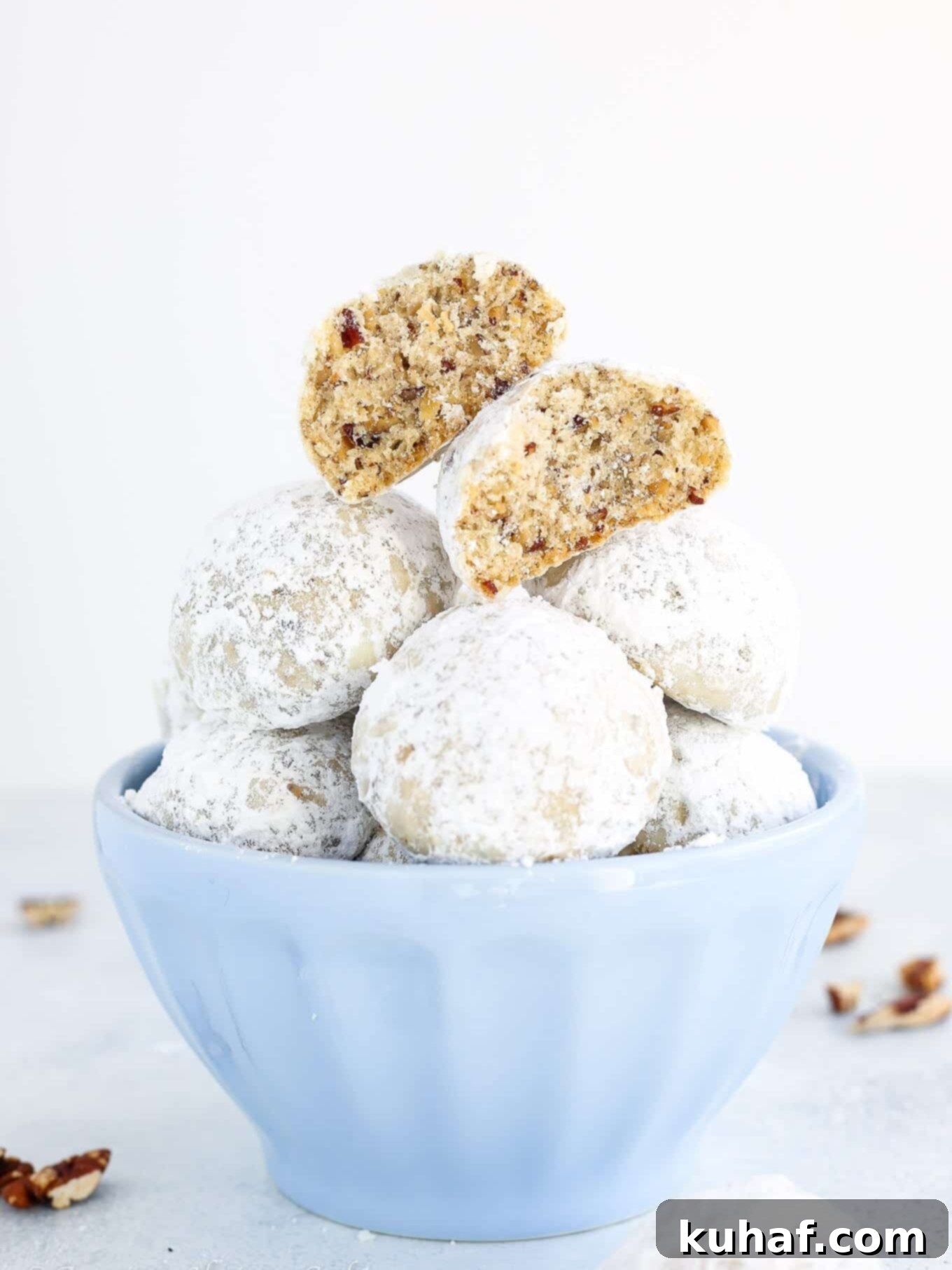 Fiesta Pecan Bites 2 Mexican wedding cookies stacked in a bowl.