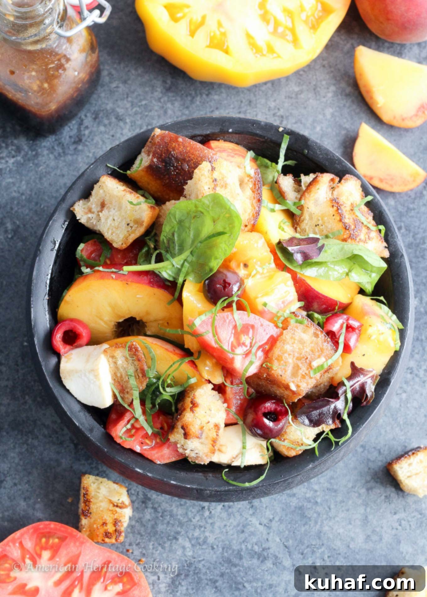 Sun-Kissed Stone Fruit Caprese Panzanella 4 Prepared Stone Fruit Caprese Panzanella Salad in a serving bowl with a spoon