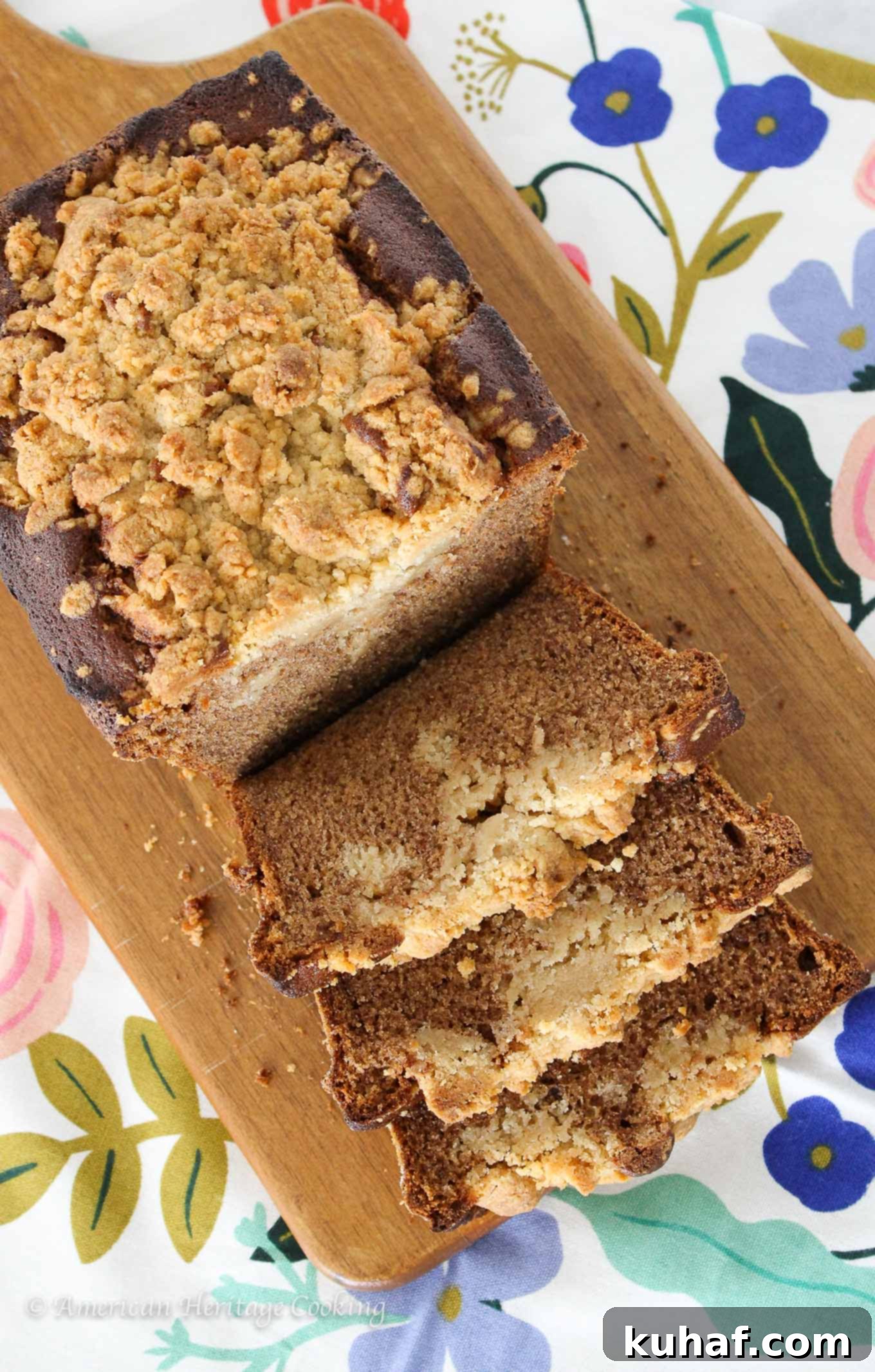 Deliciously moist cinnamon banana crumb bread with a generous streusel topping, sliced on a wooden board.