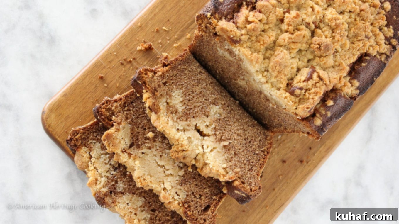 Close-up of a slice of cinnamon banana crumb bread, showcasing the golden-brown streusel and moist interior.