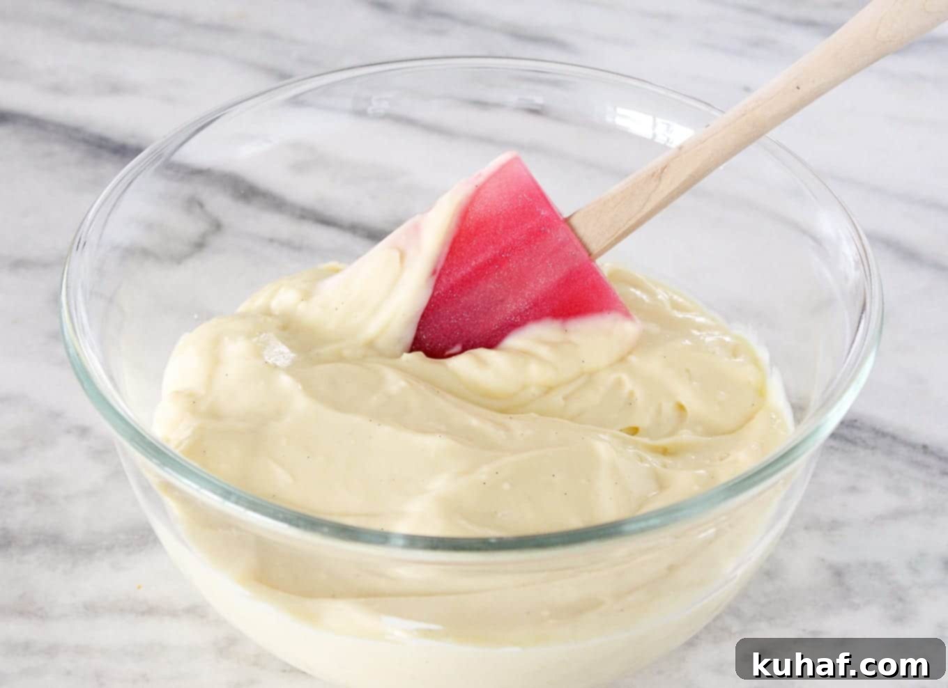 Vanilla Pastry Cream being scooped with a red silicone spatula, showcasing its rich and smooth texture.