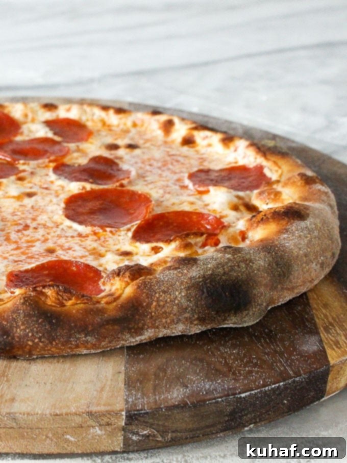 A freshly baked sourdough pizza, featuring a perfectly crusted edge, served on a rustic wooden board.