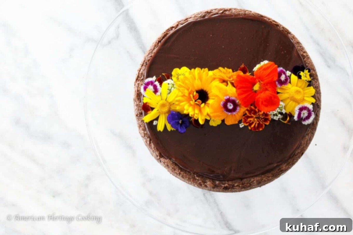 Flourless chocolate torte with a slice removed, showing its dense, moist interior, sitting on a white marble countertop.