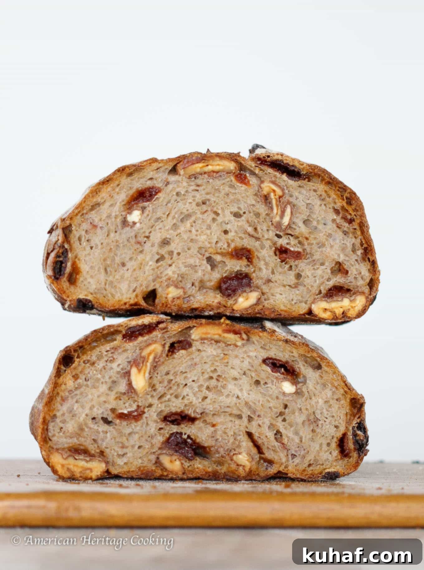 A slice of Cherry Pecan Sourdough Bread, showcasing its dense yet airy crumb, flecked with bright red cherries and hearty pecan pieces.