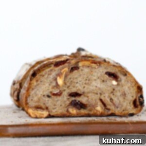 Detailed shot of a sliced Cherry Pecan Sourdough Loaf, showing the crumb texture with cherries and pecans.