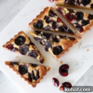 A delicious Cherry Almond Tart, perfect for any occasion. This classic French dessert features a crunchy almond sablée crust, a rich frangipane filling, and sweet, jammy fresh cherries.