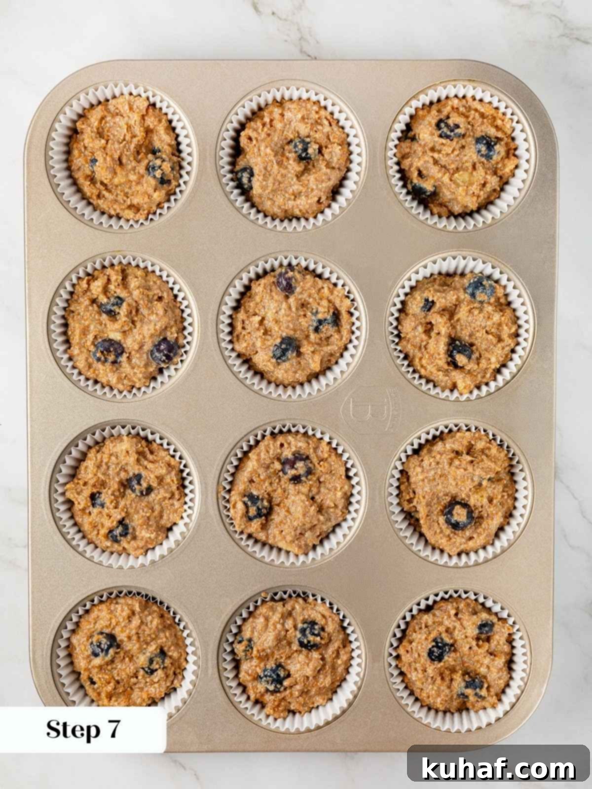 Banana protein muffin batter portioned evenly into muffin cups, ready to go into the oven.