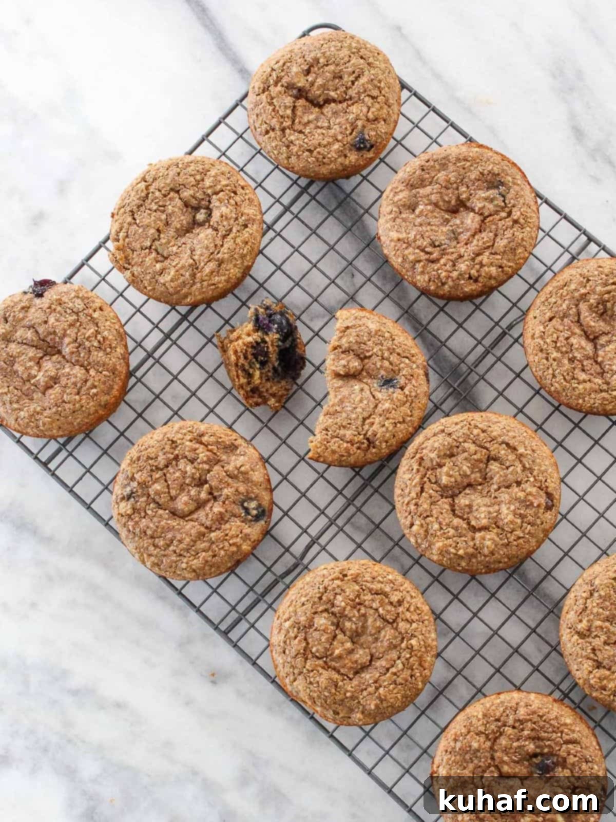 Banana muffins on a cooling rack placed on a white marble backdrop, perfect for meal prep or snacking anytime.
