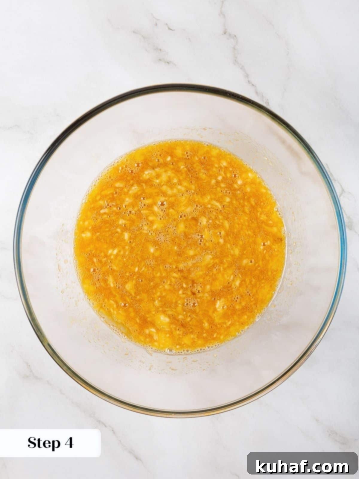 Mixing wet ingredients including eggs and banana in preparation for healthy banana protein muffins.